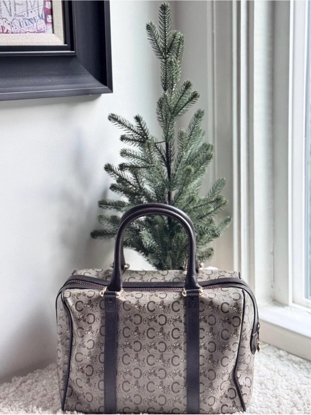 Celine Boston bag features the iconic Macadam monogram pattern and leather trim.